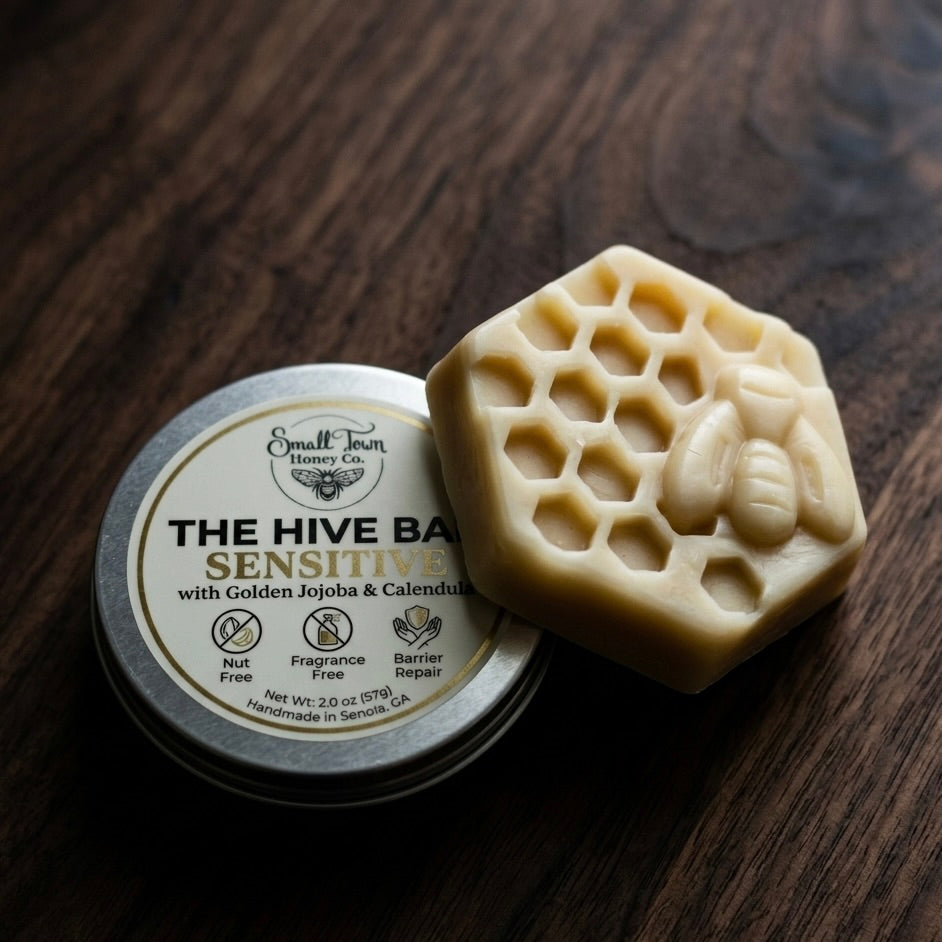 The Hive Bar Sensitive waterless lotion and container on a wooden surface