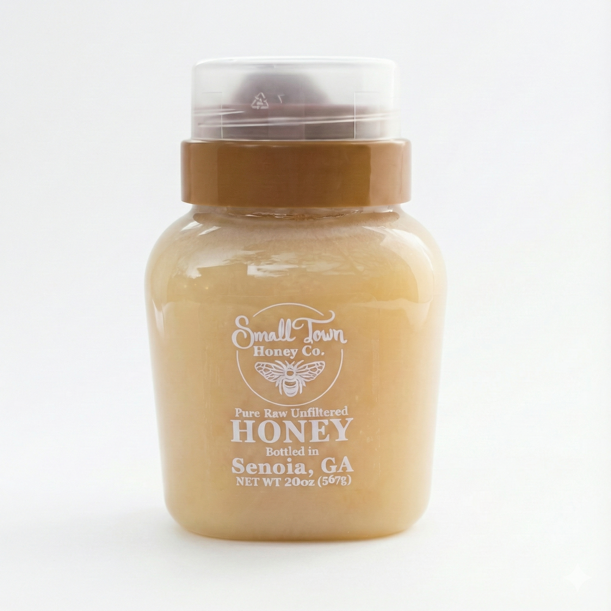 20oz bottle of Small Town Honey Co. creamy spun honey isolated on white background showing beige color and label.